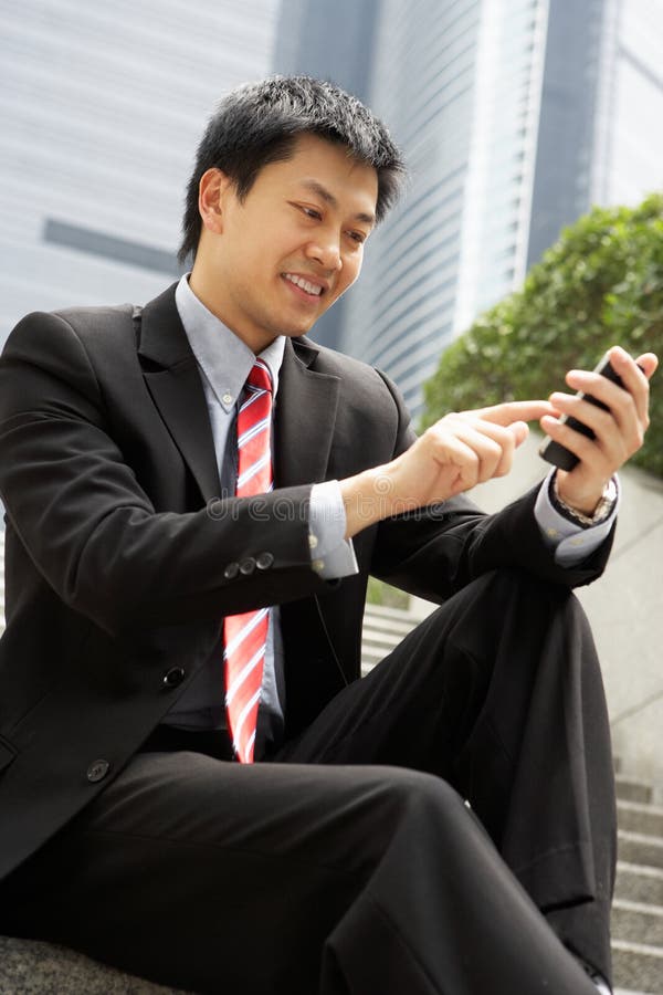 Chinese Businessman Dialling On Mobile Phone stock photo
