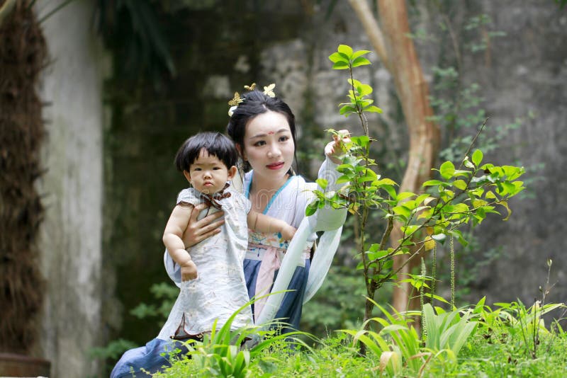 Chinese classic woman in Hanfu dress enjoy free time with baby and close friends