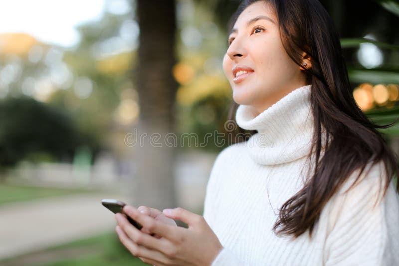 Chinese Cute Girl Using Smartphone And Walking In Tropical Park Stock 