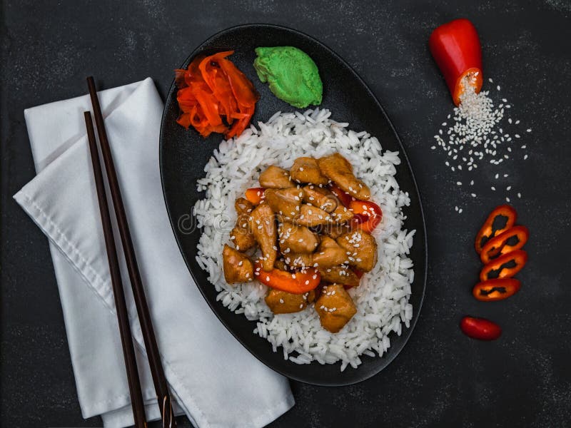 Chinese Dish Rice with Chicken with Chopsticks on Black Background. Stock Photo Image of
