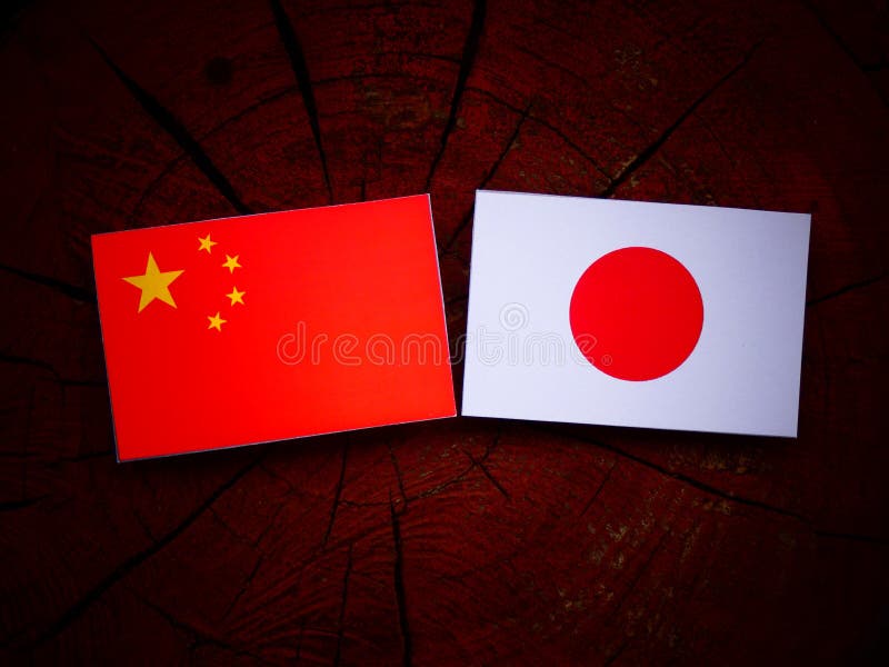 Chinese Flag with Japanese Flag on a Tree Stump Isolated Stock Image