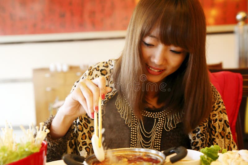 Chinese girl eating hot pot