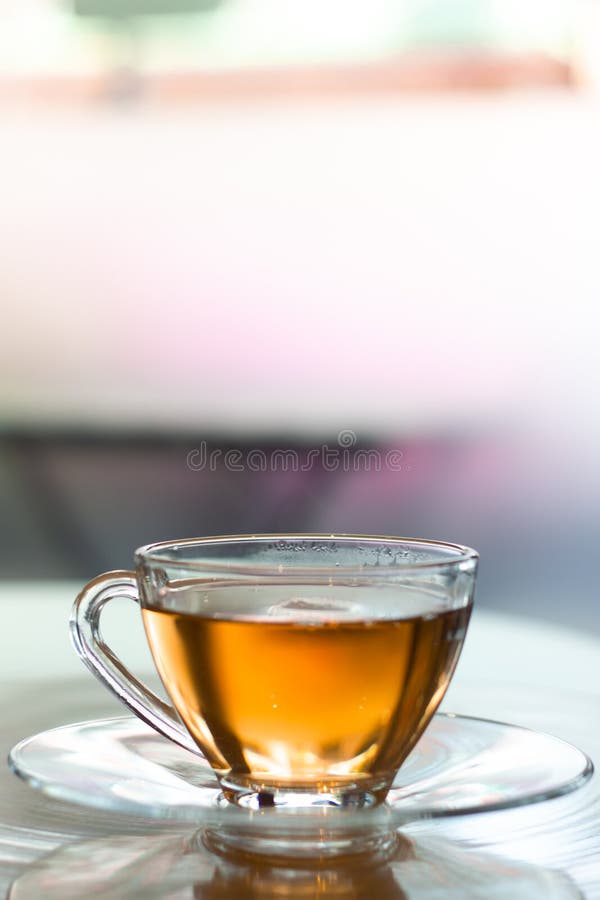 Chinese hot tea water in cup glass on dish in vertical photo