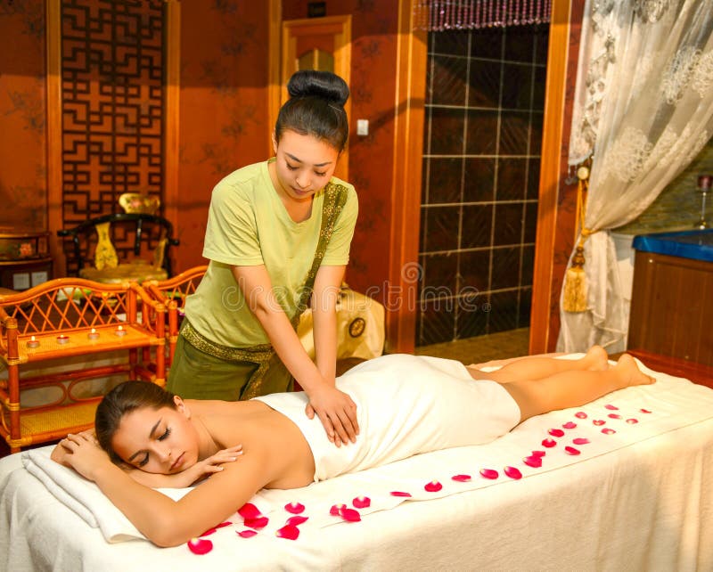 Beautiful brunette women taking chinese massage in SPA salon.