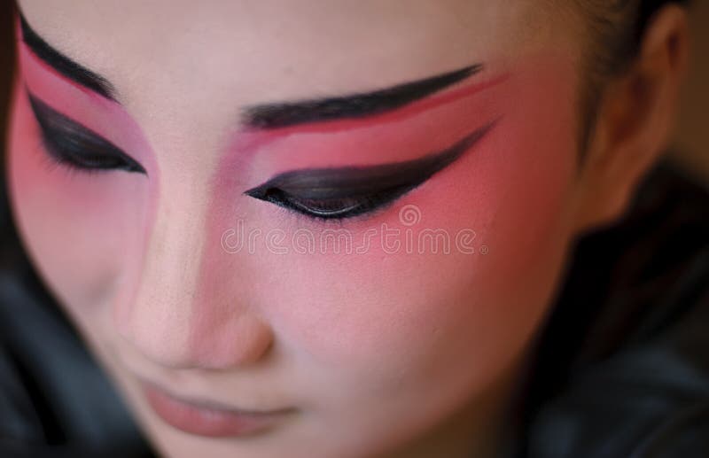 A chinese opera actress is painting her face