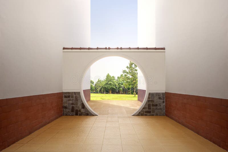 Chinese round gate with view of green grass and trees royalty free stock image
