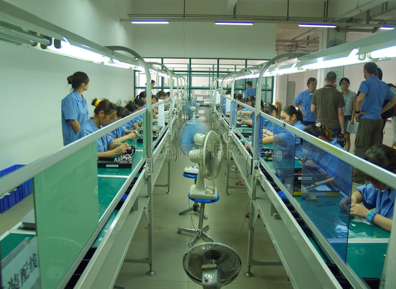 Interior view of a Chinese electronics assembly factory with girls working and assembling parts. Interior view of a Chinese electronics assembly factory with girls working and assembling parts.
