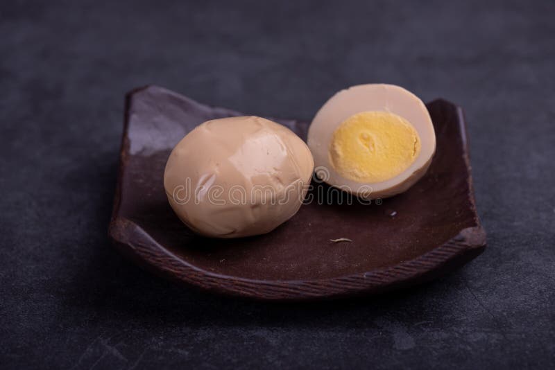 Chinese Tea Eggs, Cut or Whole Marinated Eggs in Dark Background Stock