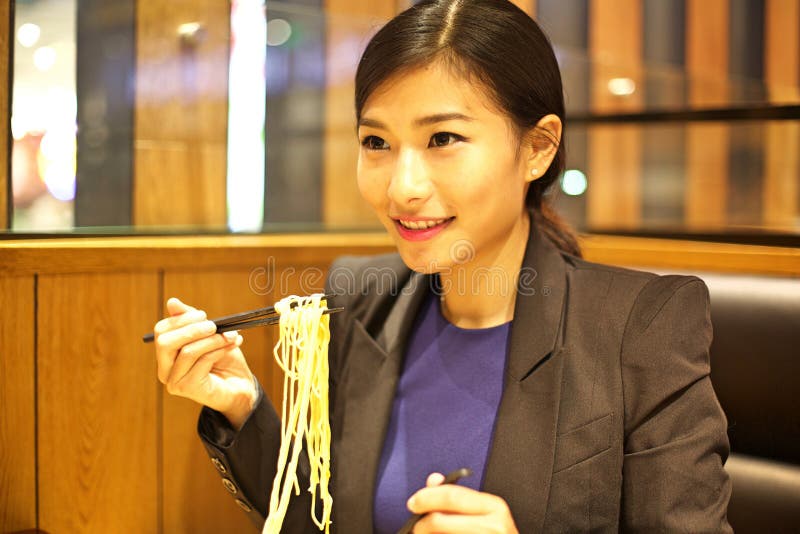Chinese Woman eating noodles in restaurant royalty free stock images Chinese Woman eating noodles in restaurant royalty free stock images