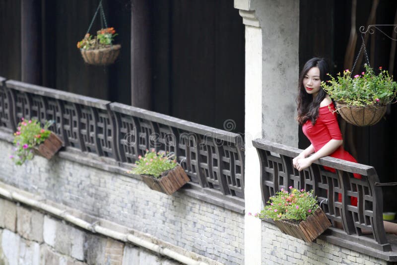 A Chinese woman in red dress in Feng Jing ancient town