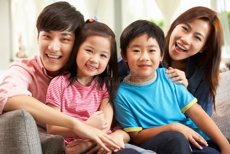 Chinese Family Relaxing On Sofa At Home Smiling. Chinese Family Relaxing On Sofa At Home Smiling