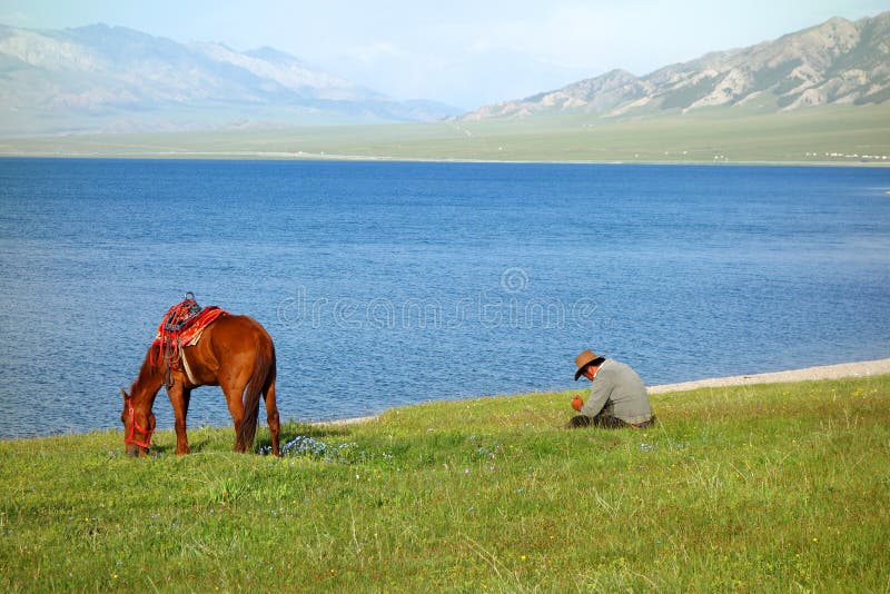 Chinesische kasachische Hirte mit Pferd am Sailimu See stockbilder Chinesische kasachische Hirte mit Pferd am Sailimu See stockbilder