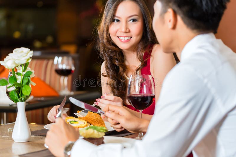 Chinesische Paare, die romantisches im fantastischen Restaurant zu Abend essen lizenzfreies stockfoto Chinesische Paare, die romantisches im fantastischen Restaurant zu Abend essen lizenzfreies stockfoto