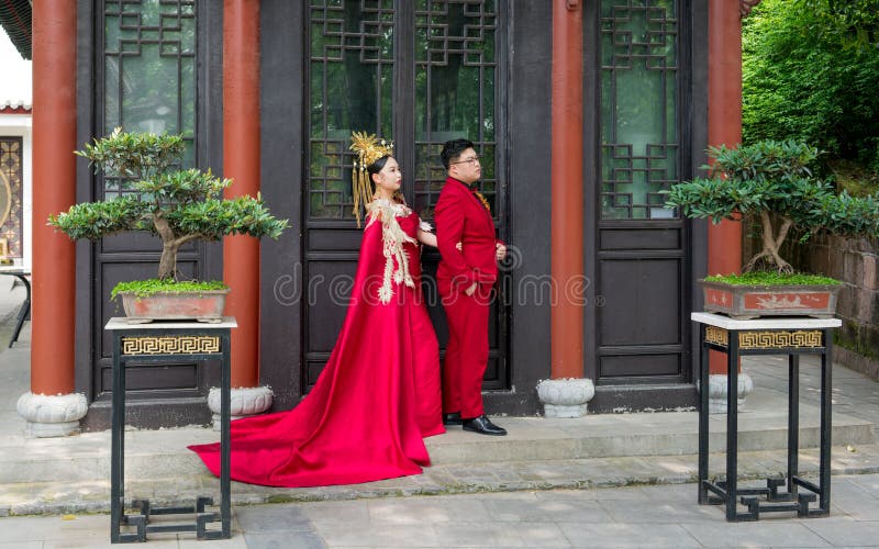 Chinesische Paare mit den traditionellen roten Kostümen, die für Heiratsbilder an Qingchuan-Pavillon in Wuhan China aufwerfen lizenzfreie stockfotografie Chinesische Paare mit den traditionellen roten Kostümen, die für Heiratsbilder an Qingchuan-Pavillon in Wuhan China aufwerfen lizenzfreie stockfotografie