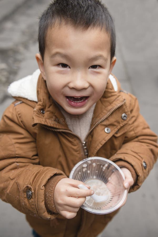 Chinesischer Junge mit leerer Schüssel in der Hand stockfotografie Chinesischer Junge mit leerer Schüssel in der Hand stockfotografie