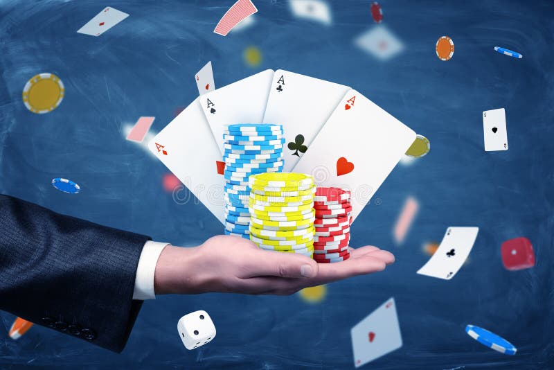 Chip e carte da gioco del casinò della tenuta della mano di un uomo d'affari con un fondo pieno delle carte e dei dadi fotografie stock libere da diritti Chip e carte da gioco del casinò della tenuta della mano di un uomo d'affari con un fondo pieno delle carte e dei dadi fotografie stock libere da diritti