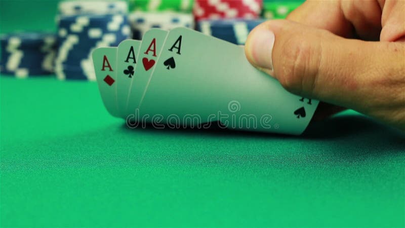 Chipy pokerowe i cztery asy na zielonym tle