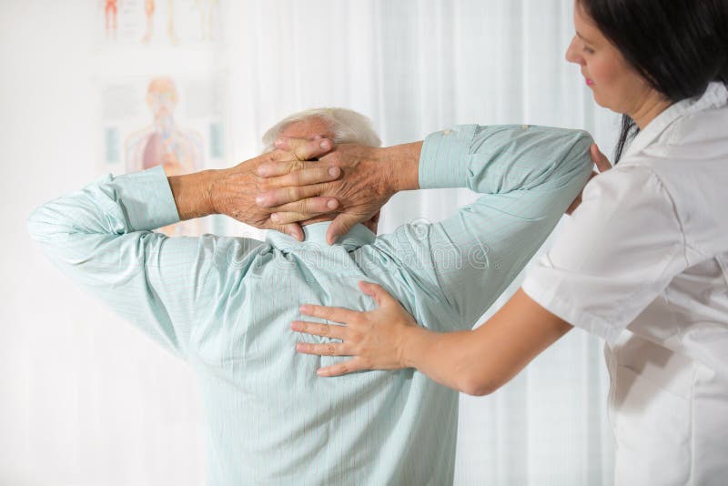 Chiropractic: Kiropraktor som undersöker den höga mannen på kontoret arkivbilder Chiropractic: Kiropraktor som undersöker den höga mannen på kontoret arkivbilder