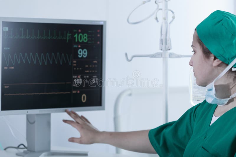 Chirurg patrzeje medycznego monitoru zdjęcia stock Chirurg patrzeje medycznego monitoru zdjęcia stock