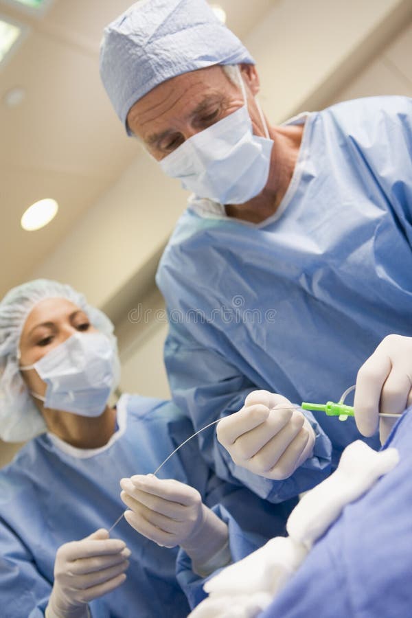 Chirurgen die Apparatuur voor Chirurgie voorbereiden stock afbeeldingen Chirurgen die Apparatuur voor Chirurgie voorbereiden stock afbeeldingen