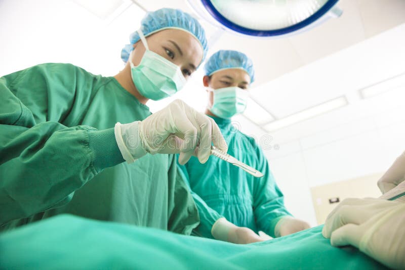 Chirurgien esthétique professionnel de médecine fonctionnant avec le scalpel photographie stock libre de droits Chirurgien esthétique professionnel de médecine fonctionnant avec le scalpel photographie stock libre de droits