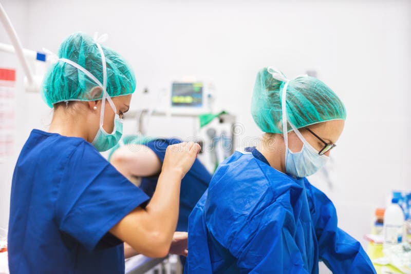 Chirurgien et assistant se préparant à la chirurgie photographie stock libre de droits Chirurgien et assistant se préparant à la chirurgie photographie stock libre de droits