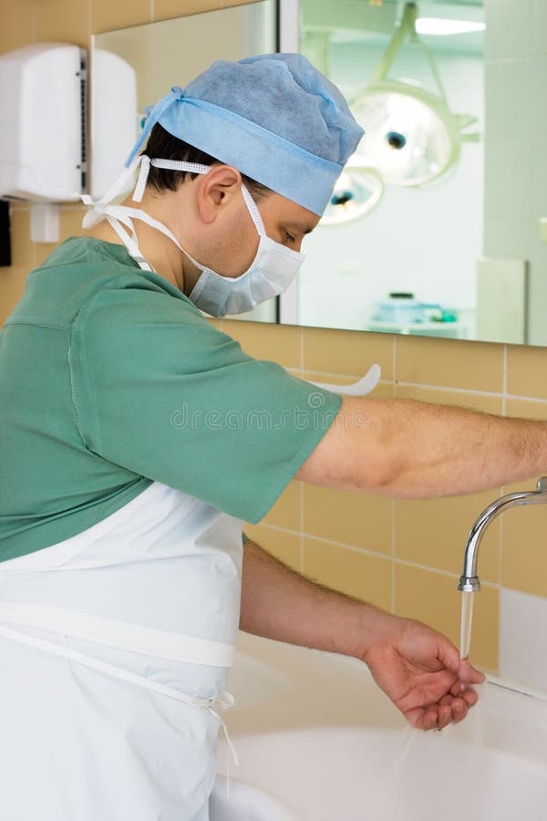 Chirurgien Washing ses mains dans la salle d'opération images stock Chirurgien Washing ses mains dans la salle d'opération images stock