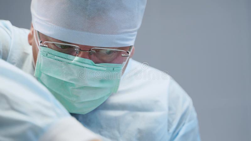 Chirurgo concentrato che esegue operazioni in un moderno centro medico. medico attento e concentrato che opera con il paziente