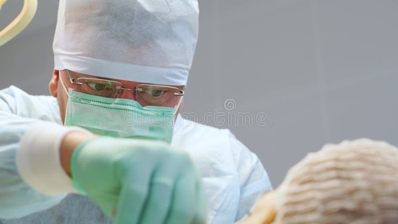 Chirurgo concentrato che esegue operazioni in un moderno centro medico. medico attento e concentrato che opera con il paziente