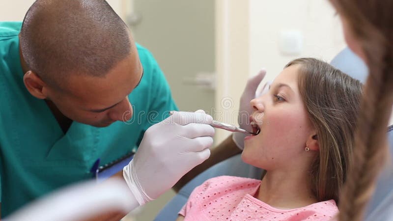 chirurgo dentista maschio che esamina una bambina