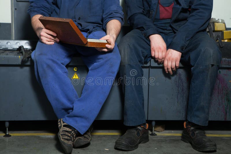 CHISINAU, EL MOLDAVIA - 26 DE ABRIL DE 2016: Trabajadores en casa de impresión Gente que trabaja en la impresora en fábrica de la imagen de archivo CHISINAU, EL MOLDAVIA - 26 DE ABRIL DE 2016: Trabajadores en casa de impresión Gente que trabaja en la impresora en fábrica de la imagen de archivo