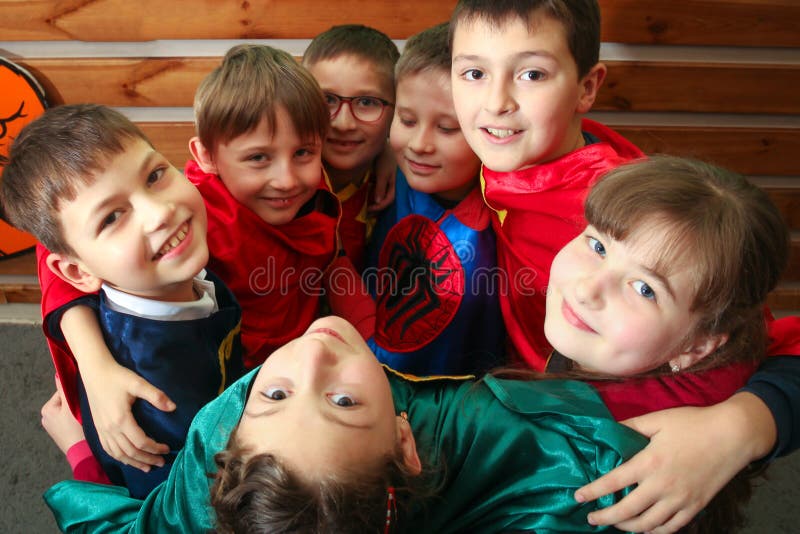 Chisinau, Republic of Moldova - December 12, 2017: A group of kids in superhero costumes are playing and hugging. Look up. stock photography Chisinau, Republic of Moldova - December 12, 2017: A group of kids in superhero costumes are playing and hugging. Look up. stock photography