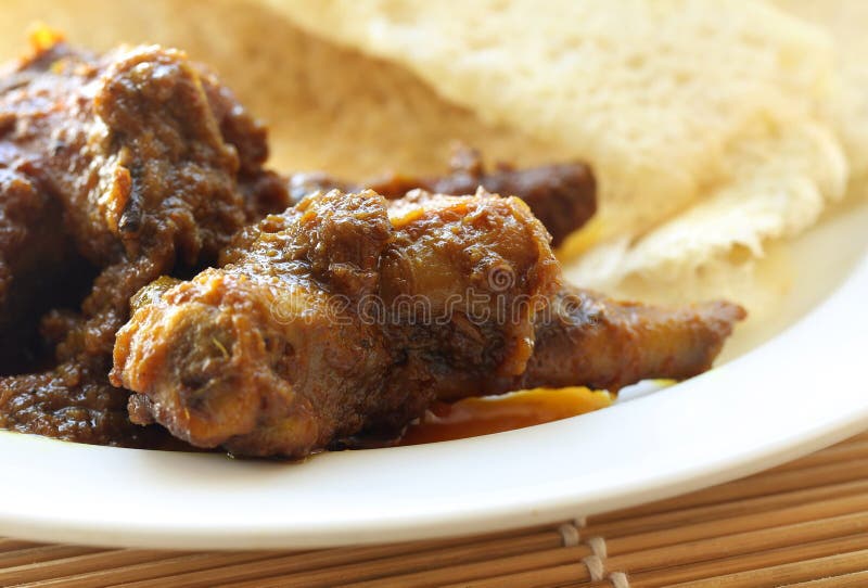 Chita ruti a Bengali cuisine with hot chicken curry in a white plate