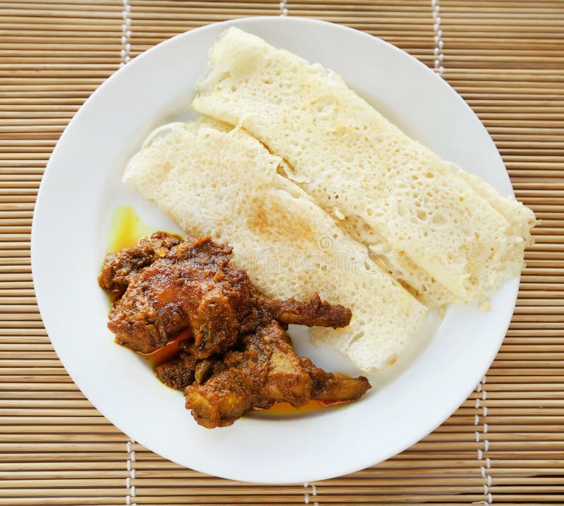 Chita ruti a Bengali cuisine with hot chicken curry in a white plate