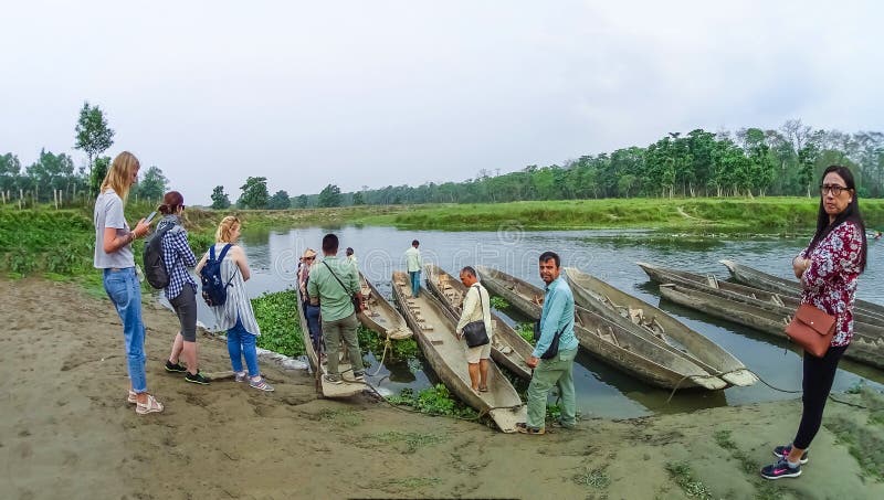 CHITWAN, Nepal - 9. April 2018: Canoeing Safari der nicht identifizierten Leute auf hölzernen Boote Pirogues auf dem Rapti-Fluss lizenzfreie stockfotografie
