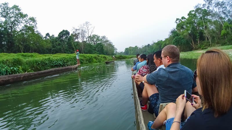 CHITWAN, Nepal - 9. April 2018: Canoeing Safari der nicht identifizierten Leute auf hölzernen Boote Pirogues auf dem Rapti-Fluss lizenzfreie stockfotografie
