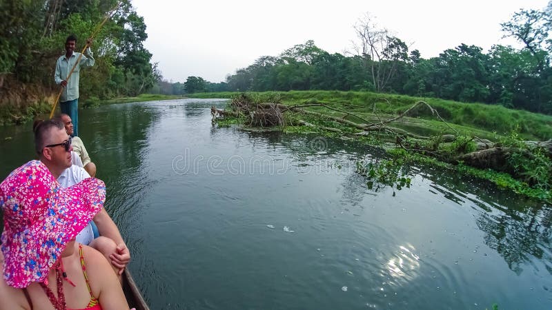 CHITWAN, Nepal - 9. April 2018: Canoeing Safari der nicht identifizierten Leute auf hölzernen Boote Pirogues auf dem Rapti-Fluss stockfotografie