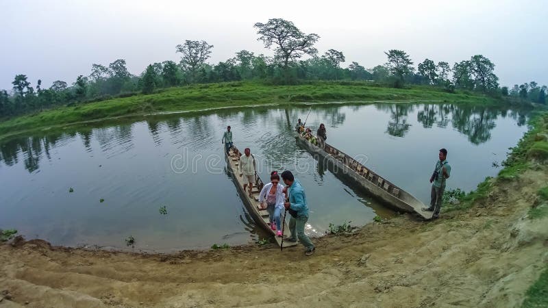 CHITWAN, Nepal - 9. April 2018: Canoeing Safari der nicht identifizierten Leute auf hölzernen Boote Pirogues auf dem Rapti-Fluss stockfoto