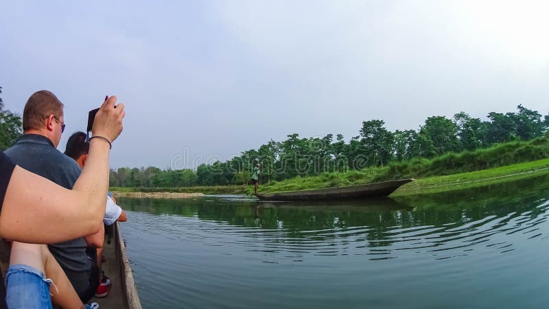 CHITWAN, Nepal - 9. April 2018: Canoeing Safari der nicht identifizierten Leute auf hölzernen Boote Pirogues auf dem Rapti-Fluss lizenzfreie stockfotografie