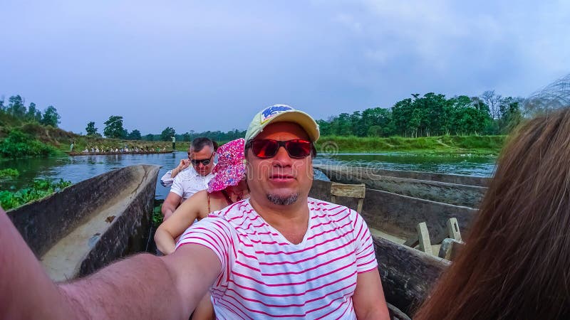 CHITWAN, Nepal - 9. April 2018: Canoeing Safari der nicht identifizierten Leute auf hölzernen Boote Pirogues auf dem Rapti-Fluss lizenzfreie stockfotos