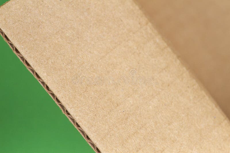 Chiuda su del bordo di scatola di cartone aperto su fondo verde immagini stock Chiuda su del bordo di scatola di cartone aperto su fondo verde immagini stock