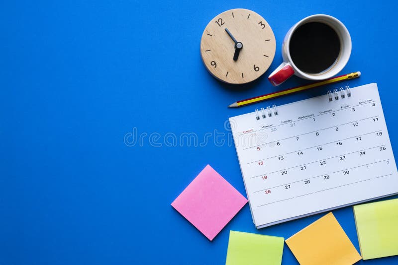 Chiuda su del calendario, del caffè, dell'orologio e della matita sulla tavola blu immagini stock libere da diritti Chiuda su del calendario, del caffè, dell'orologio e della matita sulla tavola blu immagini stock libere da diritti