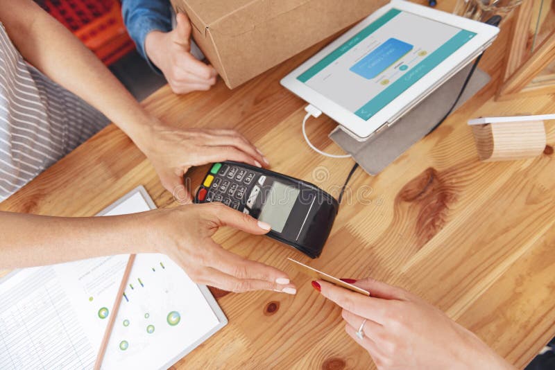 Chiuda su del cassiere che prende la carta dal cliente fotografia stock Chiuda su del cassiere che prende la carta dal cliente fotografia stock