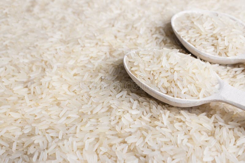 chiuda su del cereale del riso bianco e del cucchiaio di legno fotografie stock chiuda su del cereale del riso bianco e del cucchiaio di legno fotografie stock