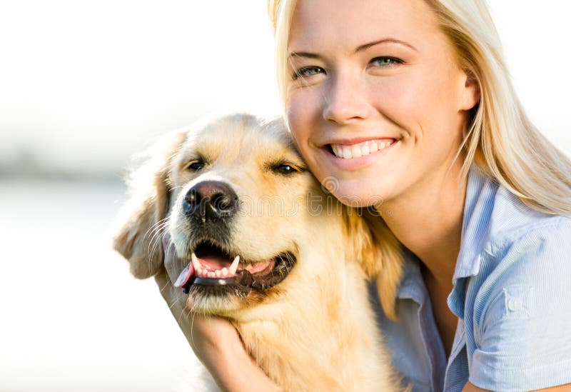 Chiuda su del golden retriever di abbraccio della donna fotografie stock