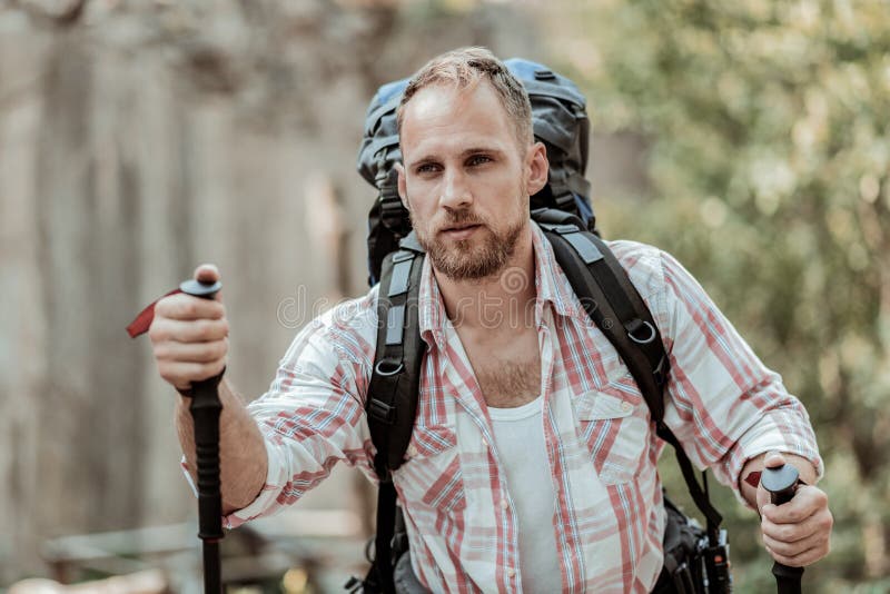 Chiuda su dell'uomo bello che fa un'escursione nelle montagne con i pali di camminata immagine stock libera da diritti Chiuda su dell'uomo bello che fa un'escursione nelle montagne con i pali di camminata immagine stock libera da diritti