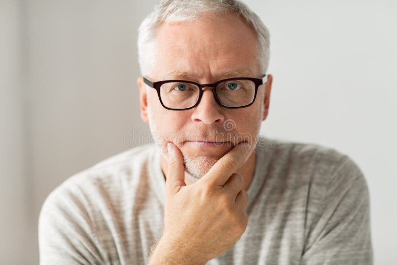 Chiuda su dell'uomo senior nel pensiero di vetro immagine stock Chiuda su dell'uomo senior nel pensiero di vetro immagine stock