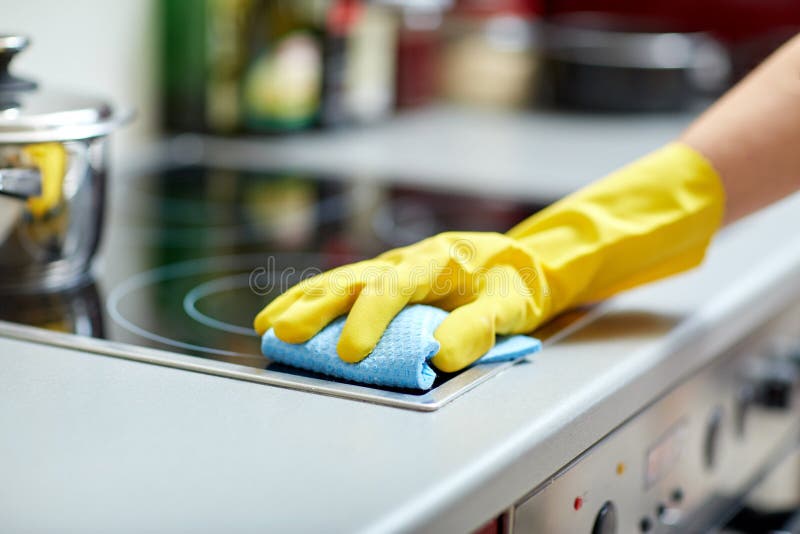 Chiuda su della cucina del fornello di pulizia della donna a casa