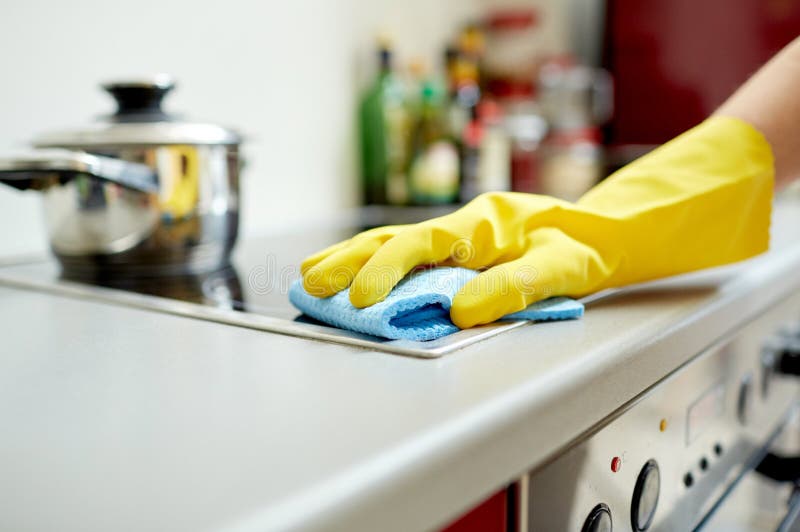 Chiuda su della cucina del fornello di pulizia della donna a casa fotografia stock Chiuda su della cucina del fornello di pulizia della donna a casa fotografia stock