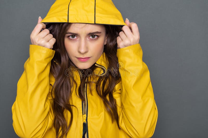 Chiuda su della ragazza caucasica calma vestita in impermeabile giallo in studio fotografia stock libera da diritti Chiuda su della ragazza caucasica calma vestita in impermeabile giallo in studio fotografia stock libera da diritti